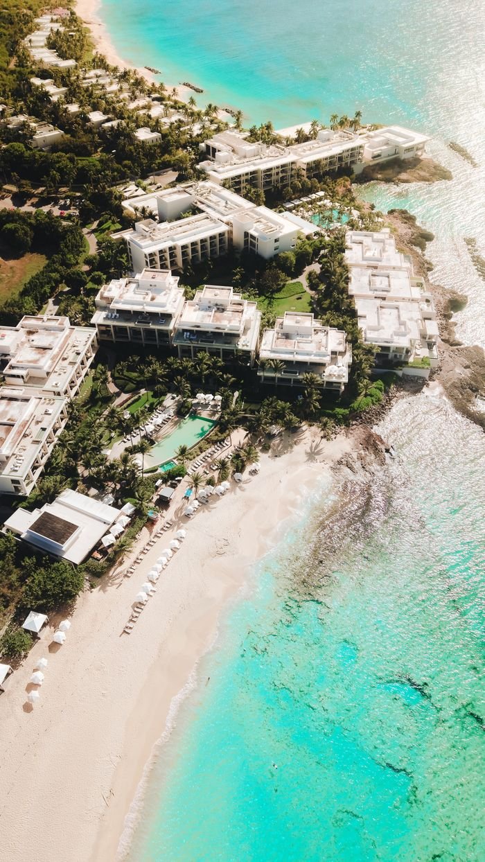 Breathtaking aerial shot of a luxury beachfront resort on Anguilla's clear turquoise waters.